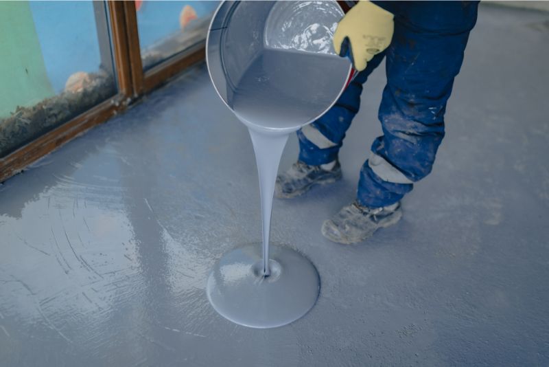 A photo of a man poring epoxy resin on a surface