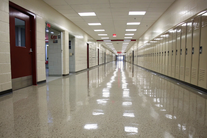lossy epoxy flooring in empty school hallway with lockers and fluorescent lighting in Sutherland Shire educational facility