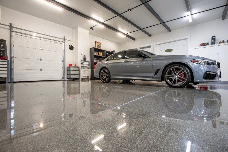 Completed epoxy garage floor installation with car parked in Sutherland Shire home